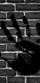 Black handprint on a rugged brick wall design for mobile.