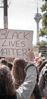 A Black Lives Matter protest with people holding signs in a city setting.