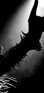 Black metal arm with spikes and rock gesture in spotlight.