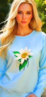 Blonde woman in light blue sweater with floral design outdoors.