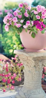 Beautiful garden with pink flowers on a stone pedestal.
