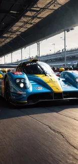 Blue and yellow race car on track in the sunlight.