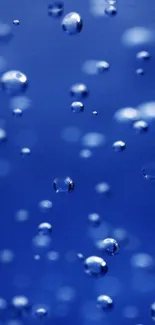 Blue bubbles floating in deep blue background mobile wallpaper.