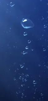 Mobile wallpaper with blue bubbles rising in dark ocean background.