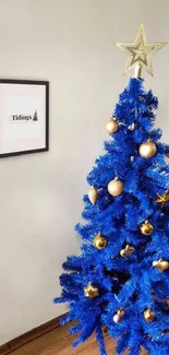 Blue Christmas tree with gold decorations and star topper.