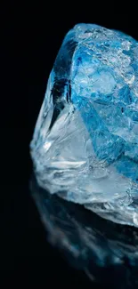 Blue crystal on a black background, reflecting light.