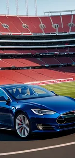 Sleek blue electric car on racetrack with red stadium backdrop.