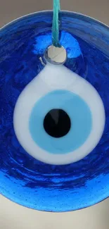Blue evil eye charm with vibrant hues and circular design.