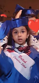 Child in blue graduation gown at ceremony.