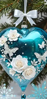 Blue heart ornament with floral and butterfly designs on a festive tree.