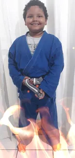 Smiling child in blue judo suit in front of curtains.