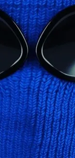 Blue knit texture with black sunglasses wallpaper.