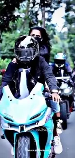 A striking blue motorcycle leads a group ride through a lush forest.