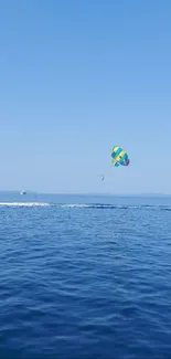 Parasailing adventure over a blue ocean with clear sky.