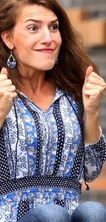 Woman in blue patterned dress showing excitement.