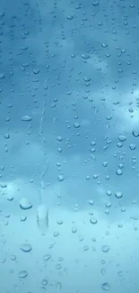 Raindrops on a window with a calming blue sky in the background.