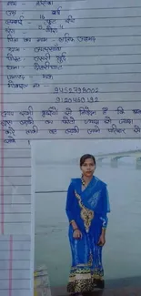 Woman in a blue saree standing by a river with a serene expression.