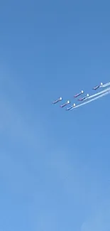 Vintage airplanes flying in a clear blue sky in formation.