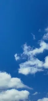 Clear blue sky with fluffy white clouds.