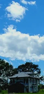 Serene farmhouse under blue sky and clouds.