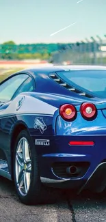 Blue sports car on a racetrack in daylight.