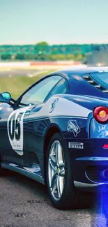 Blue sports car on race track, sleek design.