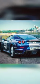 Dynamic blue sports car on race track wallpaper.