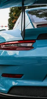 Blue sports car on urban street with city background.