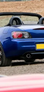 Blue sports car with black interior on road.