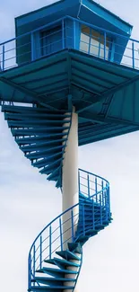 Modern blue tower with spiral stairs against a clear sky, ideal for mobile wallpaper.