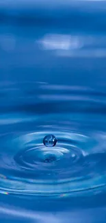 Close-up of a blue water ripple with a droplet in the center.