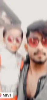 Blurred portrait of two people wearing red sunglasses.