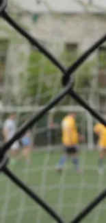 Blurred soccer match viewed through a fence.