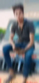 Blurred image of a person sitting on a vehicle in an urban setting.