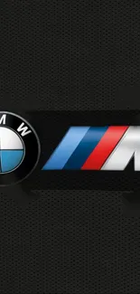 BMW M logo on a black textured background wallpaper.