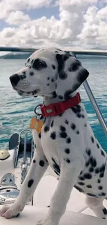 Dalmatian puppy on a boat with blue ocean background and cloudy sky.