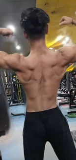 Muscular back pose in gym setting, showcasing strength and fitness.