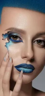 Bold blue artistic portrait with striking makeup design.