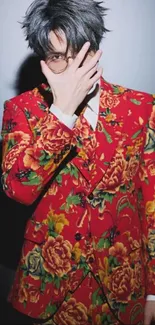 Man in bold floral suit with hand over face.