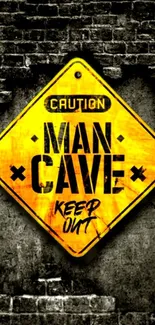 Yellow 'Man Cave' caution sign on brick wall background.