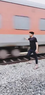 Person stands near moving train on tracks.