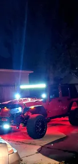 Jeep illuminated in red at night on residential driveway.