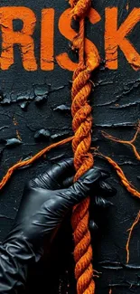 Risk concept with orange rope and black glove on textured background.