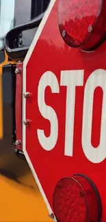 Closeup of a red stop sign on a yellow school bus.