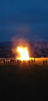 Nighttime bonfire gathering under a dark sky.