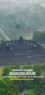 Aerial view of Borobudur Temple amidst lush greenery and misty landscape.