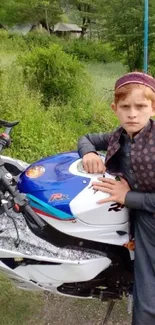 Young boy in traditional attire with motorbike in scenic countryside.