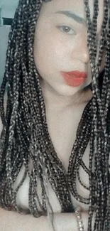 A woman with long, braided hair and red lips on a wallpaper.