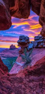 Desert rock formation framing vibrant sunset sky.