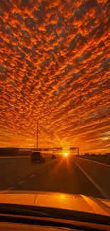 Fiery sunset over highway with orange sky.